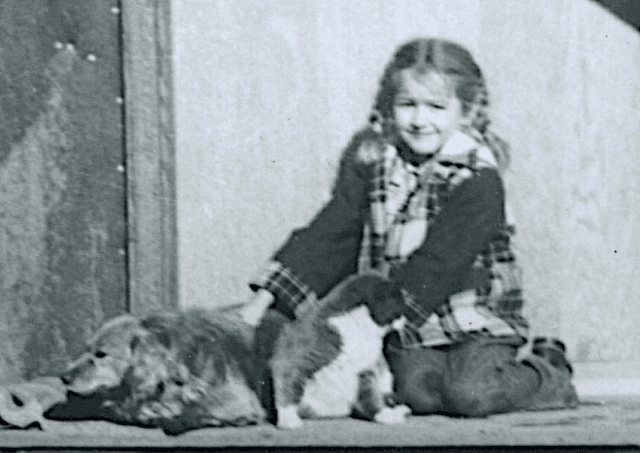 image for Pam Doan on front porch with Sparky and the three legged cat Tom.